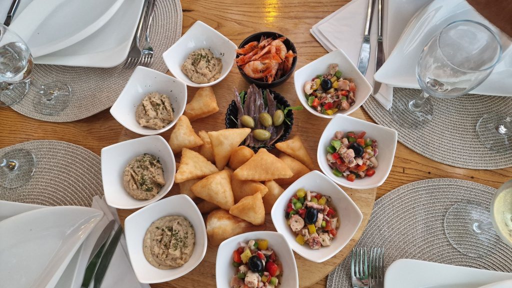 Tisch mit Oliven, Brot und dalmatinischen Spezialitäten beim Abendessen