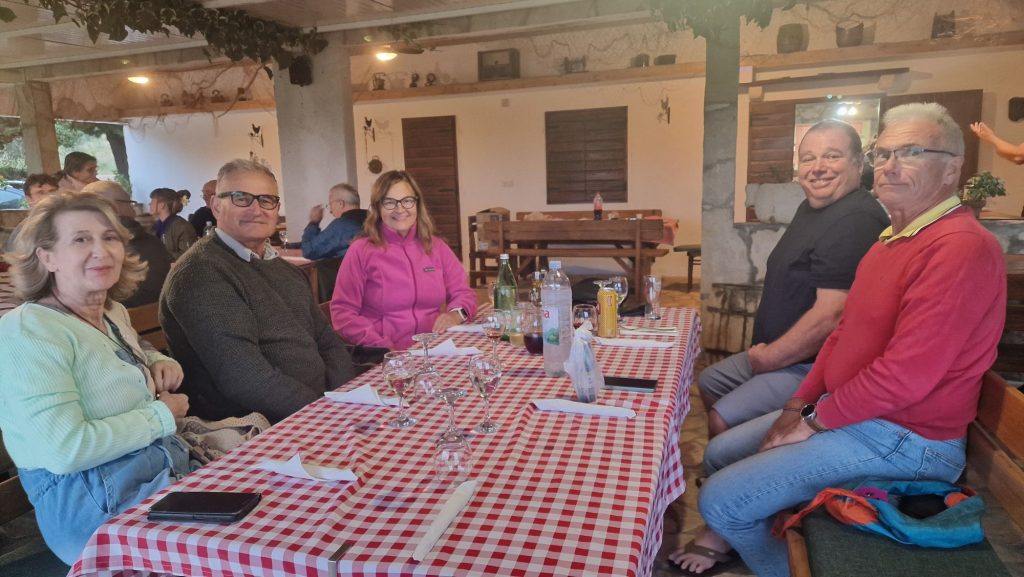 Innenraum einer Konoba mit karierten Tischdecken und Gästen