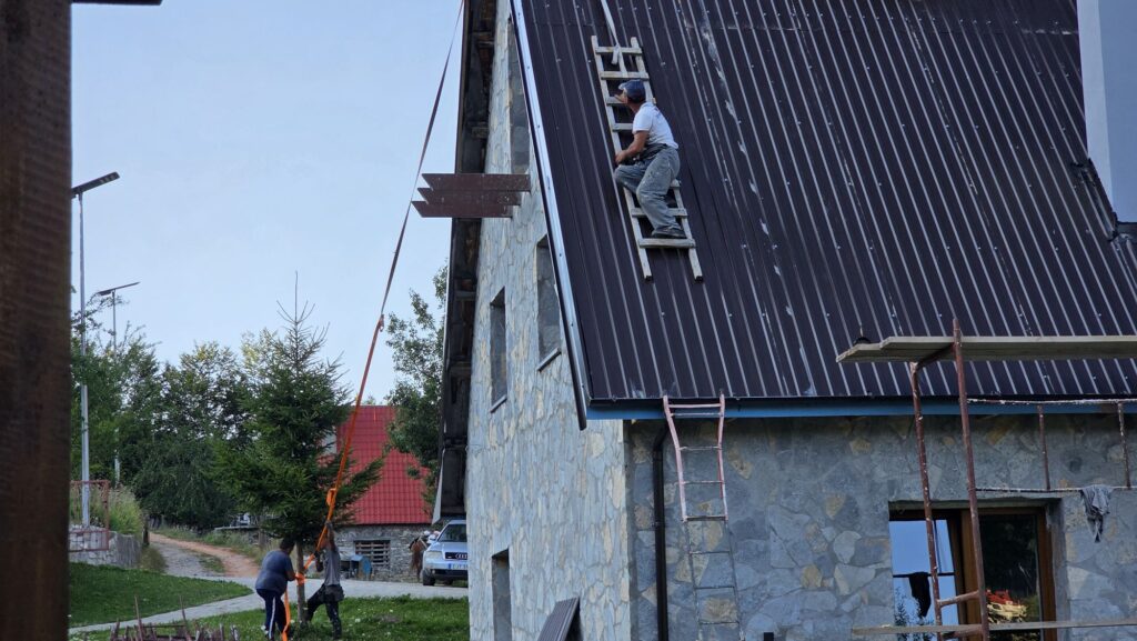 Handwerker bei den letzten Arbeiten auf einem Dach in Lëpushë