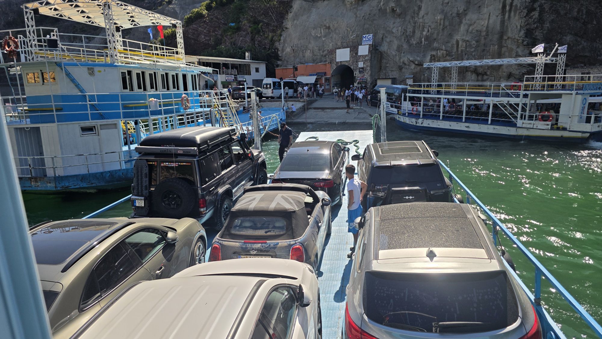 Autofähren und Boote am Anleger von Koman